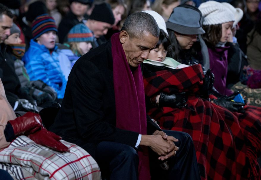 President Barack Obama bows his head in prayer during the National Christmas Tree Lighting ceremony at the Ellipse in Washington, Thursday, Dec. 3, 2015. Picture by Carolyn Kaster | AP